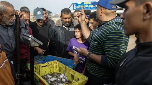 Gazans gather at a fish market on Monday morning to buy seafood