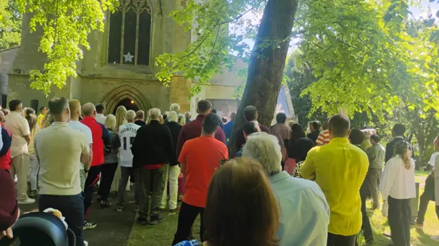 Mourners watch funeral