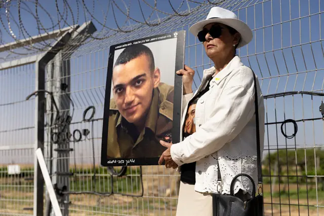 Varda Ben Baruch holds a photo of her grandson Israeli- American hostage Edan Alexander during a rally of families of hostages