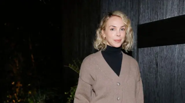 A woman with a blonde bob smiling at the camera
