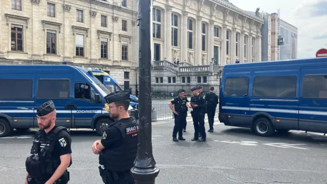 police officers and vans are parked in front of the courthouse