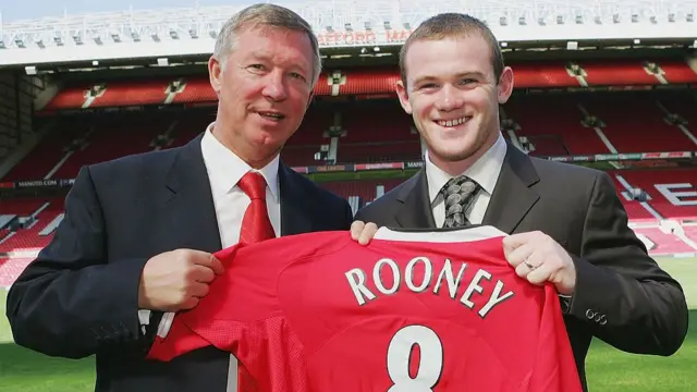 Sir Alex Ferguson of Manchester United poses with Wayne Rooney and a United shirt
