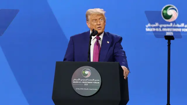 Trump stands at a podium and speaks