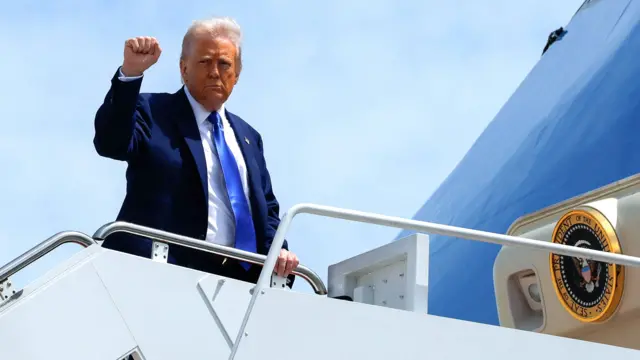 Donald Trump raises his fist as he boards Air Force One