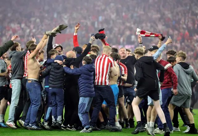 Sunderland fans celebrate on the pitch after beating Coventry 3-2 on aggregate