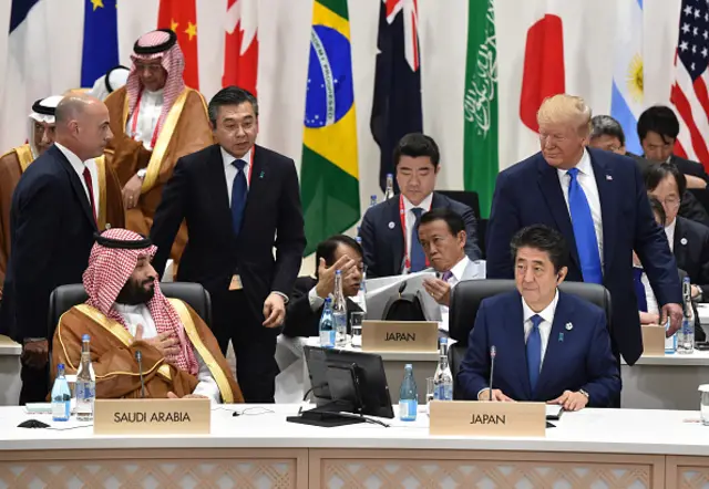Trump looks back at Bin Salman as he arrived at the session on women's workforce participation, future of work, and aging societies at the G20 Summit on June 29, 2019 in Osaka