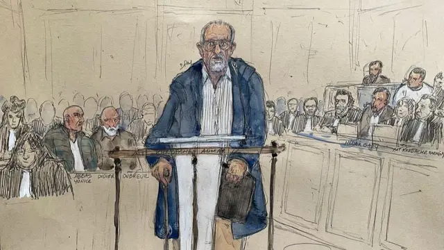 A court sketch showing an old man standing in the middle with several people behind looking on at him