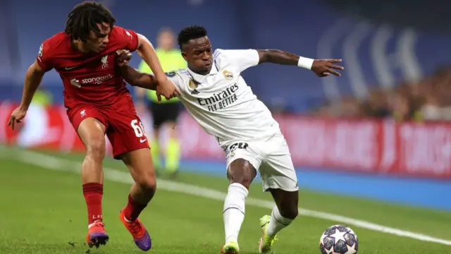 Vinicius Junior of Real Madrid keeps his balance as he is challenged by Trent Alexander-Arnold of Liverpool
