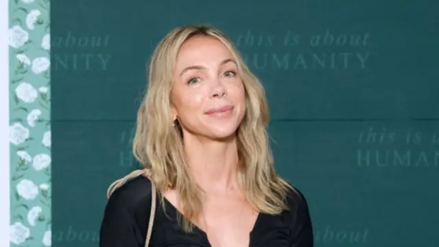Harouche headshot smiling at the camera in front of a teal background
