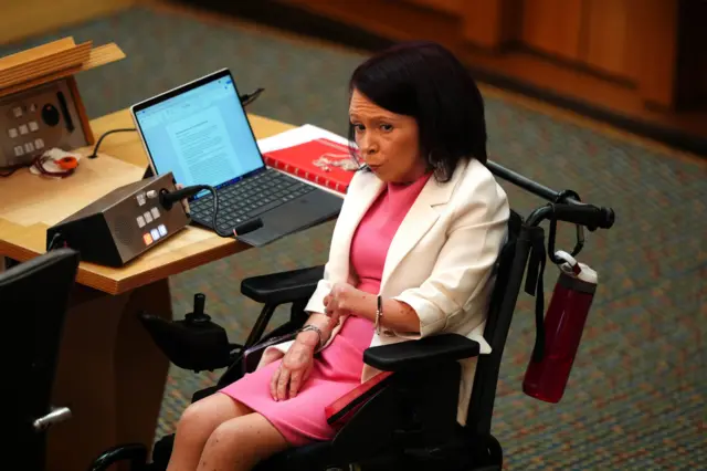 Pam Duncan-Glancy in her wheelchair at her desk in the Holyrood chamber