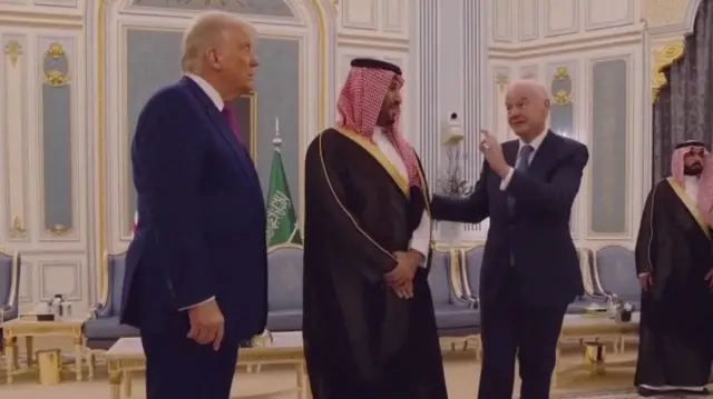Fifa president Gianni Infantino touching MBS's arm and doing an OK sign with his hand