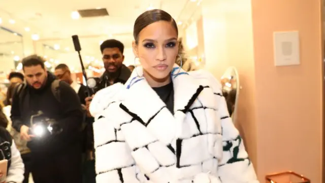 Cassie Ventura wearing a white fur coat over a black shirt