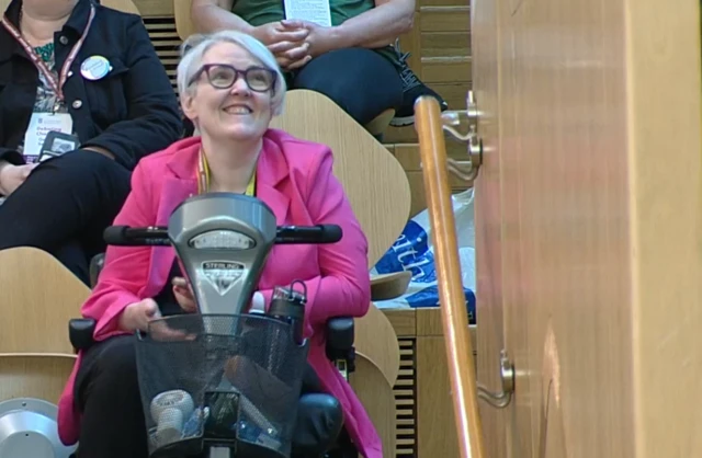 Stacey Adam watches her MSP husband's speech from the public gallery at Holyrood
