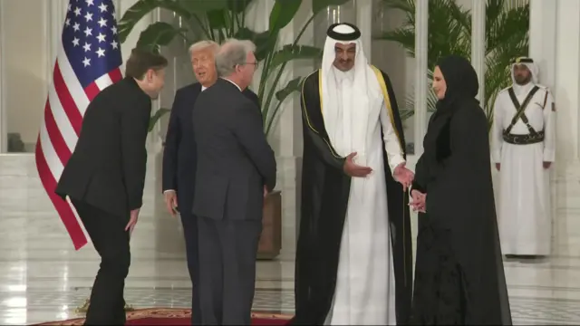 In the entrance foyer to the palace, Musk is doubled over laughing as Trump speaks with a smile on his face