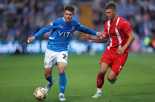 Oliver Norwood of Stockport County runs with the ball whilst under pressure from Jamie Donley of Leyton Orient