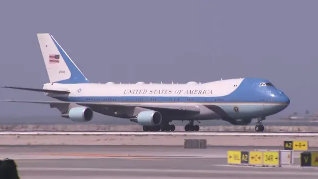 Blue and white plane with United States of America written on in landing on tarmac