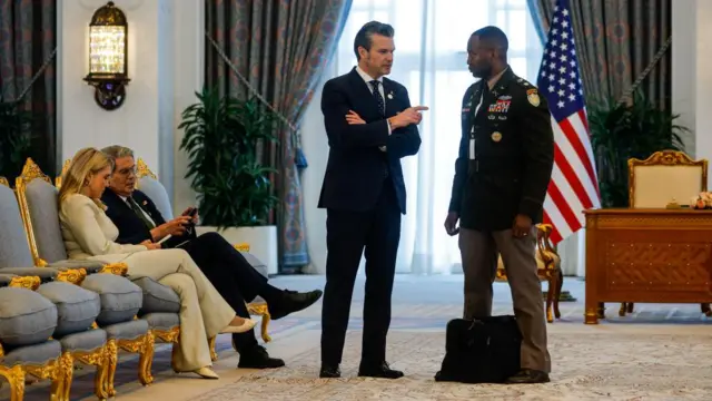White House Press Secretary Karoline Leavitt sits as US Defence Secretary Pete Hegseth speaks to an official