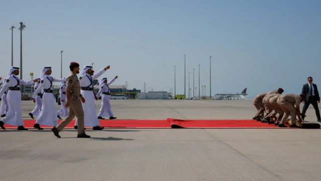 Security officers roll out a red carpet on the day of the arrival of U.S. President Donald Trump at Hamad International Airport