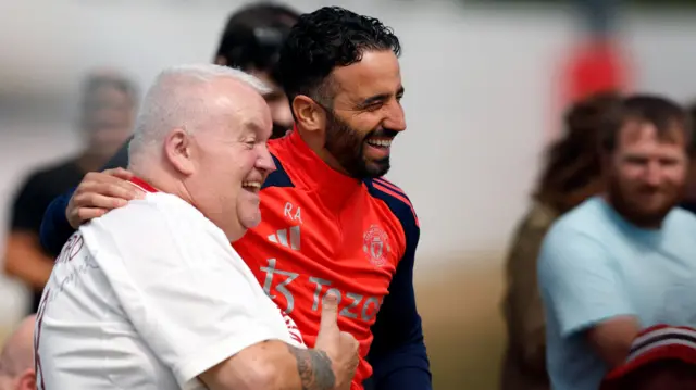 Manchester United head coach Ruben Amorim poses for a picture with a fan at an open training session on 14 May 2025