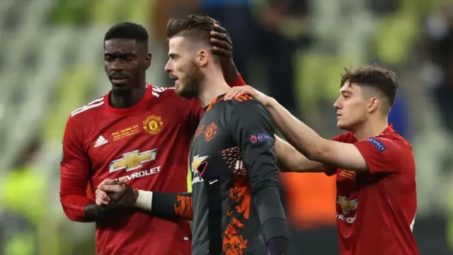 Manchester United players console David de Gea after they lose the 2021 Europa League final to Villarreal on penalties