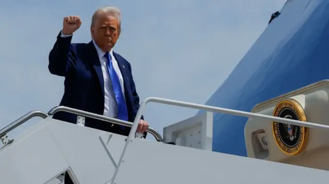 US President Donald Trump gestures, while he boards Air Force One, as he departs for Saudi Arabia, Qatar and the United Arab Emirates