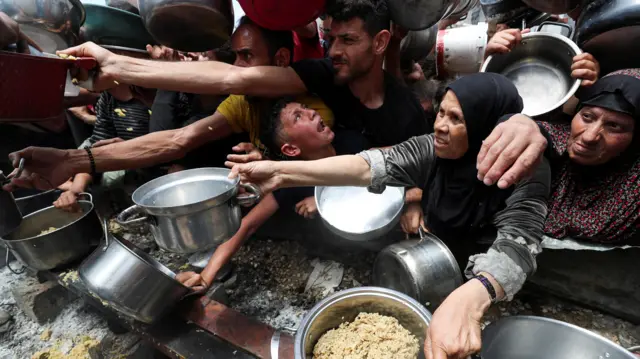 Palestinians wait to receive food