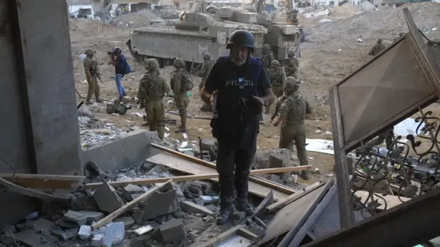 Bowen stands near destroyed buildings in Gaza