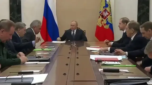 Putin sitting astatine  the caput  of a table with Russian officials and generals. Among them are FM Lavrov, defence curate  Andrei Belousov, National Guard commandant  Viktor Zolotov, main  of the General Staff Valery Gerasimov, and FSB main  Alexander Bortnikov