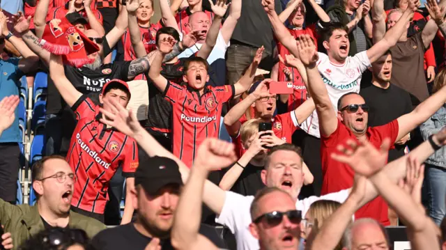 Walsall fans celebrating winning at Chesterfield in the first leg