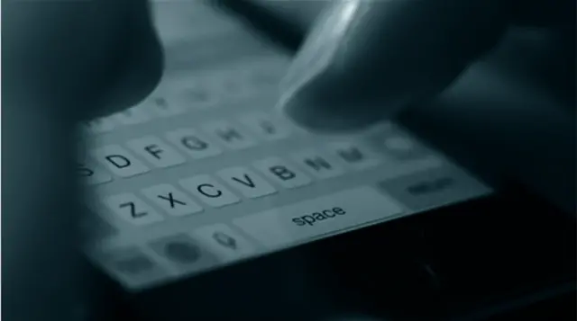 A phone keyboard with thumbs tapping on the keyboard