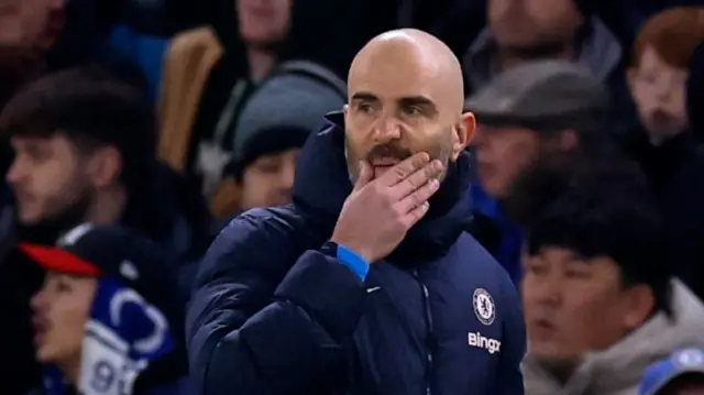Chelsea manager Enzo Maresca looking pensive with his hand on his face