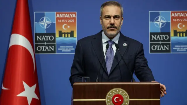 Hakan Fidan speaking at a podium