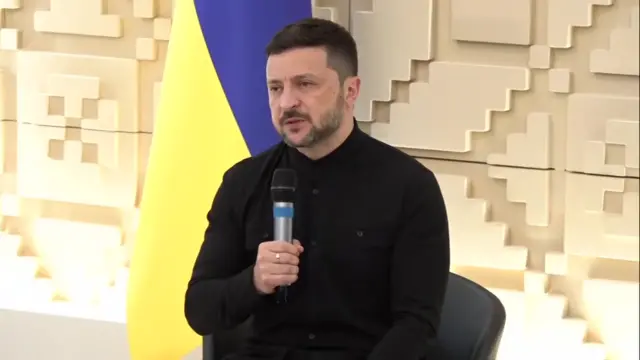 Zelensky speaks into a microphone