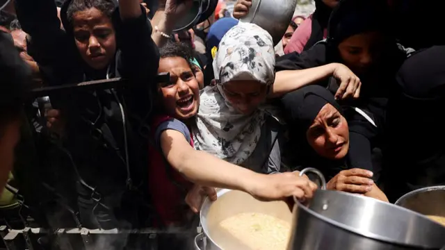 Women in a crowd struggle to get food