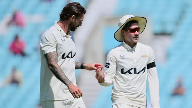 Surrey captain Rory Burns with bowler Jordan Clark