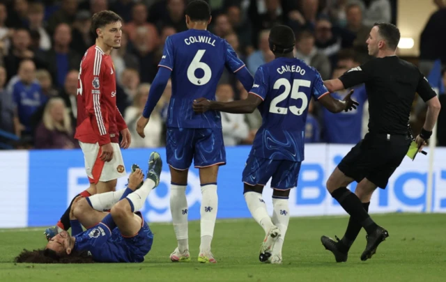 Manchester United's Manuel Ugarte is shown a yellow card by referee Chris Kavanagh