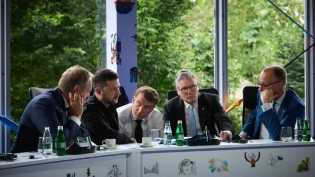 World leaders confer around a table.