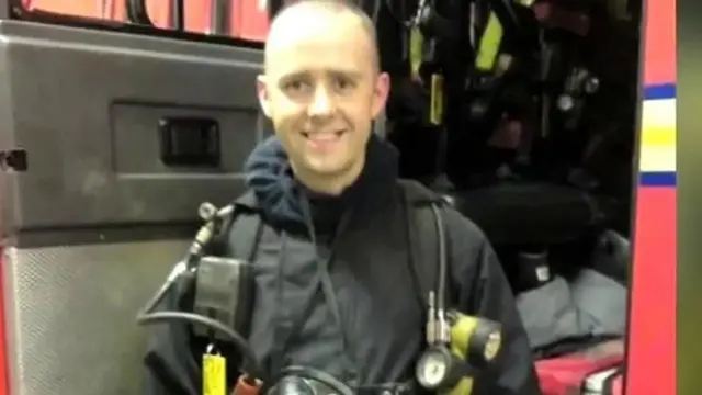 Stephen Hunt in his uniform next to a fire engine