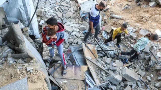 Palestinians inspect the site of an Israeli strike on a house, in Jabalia, in the northern Gaza Strip