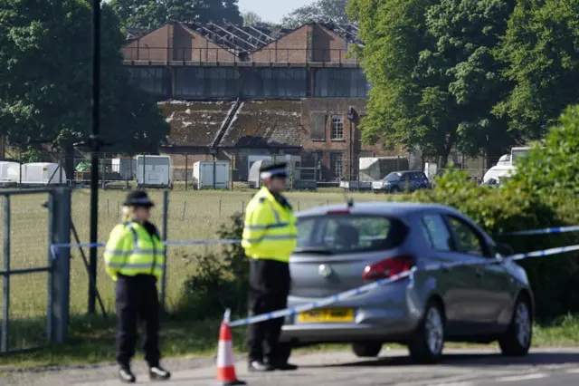 Police stand in front of the damaged building