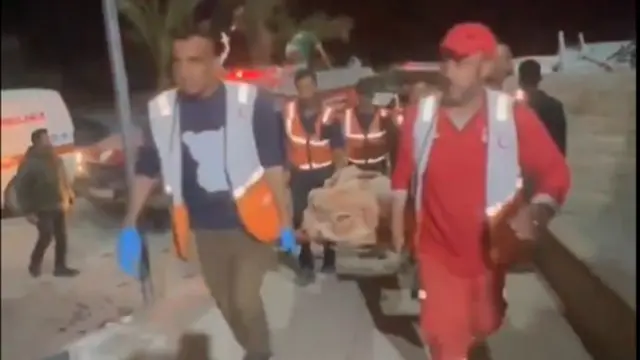 Rescue workers carry injured person into hospital on stretcher