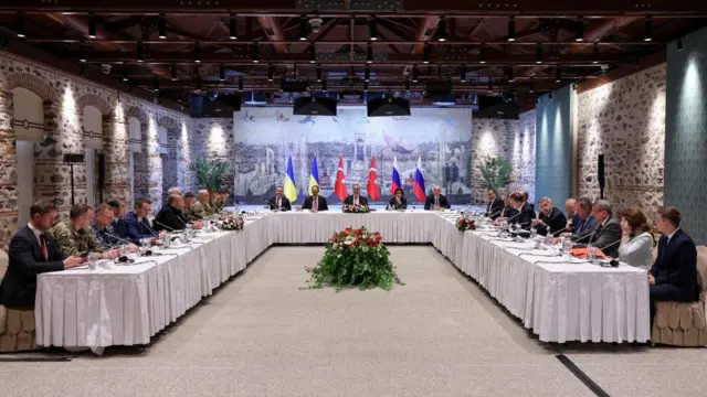Turkish Foreign Minister Hakan Fidan (C) speaking at the meeting of Ukrainian (L) and Russian (R) delegations at the Presidential Office in Istanbul.