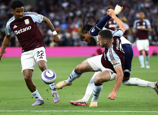 Aston Villa's Ian Maatsen and Aston Villa's John McGinn in action with Tottenham Hotspur's Djed Spence