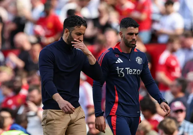 Manchester United manager Ruben Amorim talks to Assistant manager Carlos Fernandes as they leave the pitch