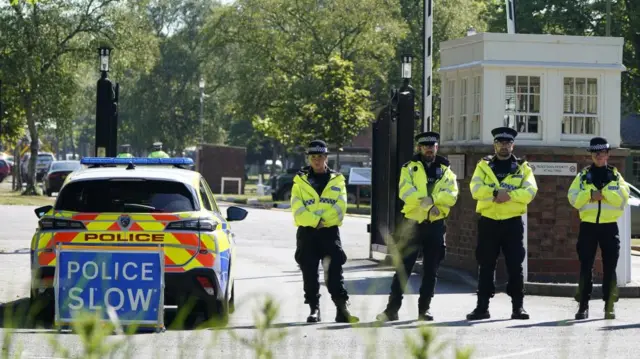 Police officers patrol at a cordon near the scene of a fire at Bicester Motion in Oxfordshire