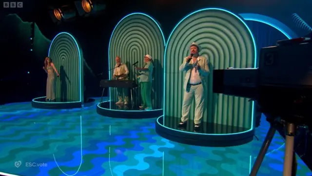 Peter Sue and Marc perform on stage on green background to celebrate Switzerland Eurovision record