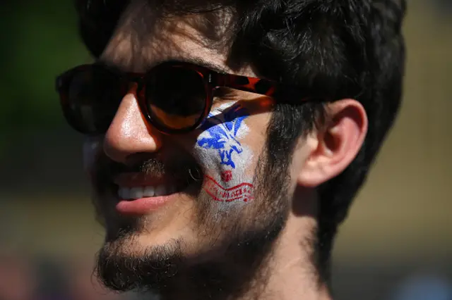 A fan of Crystal Palace looks on, while wearing face paint