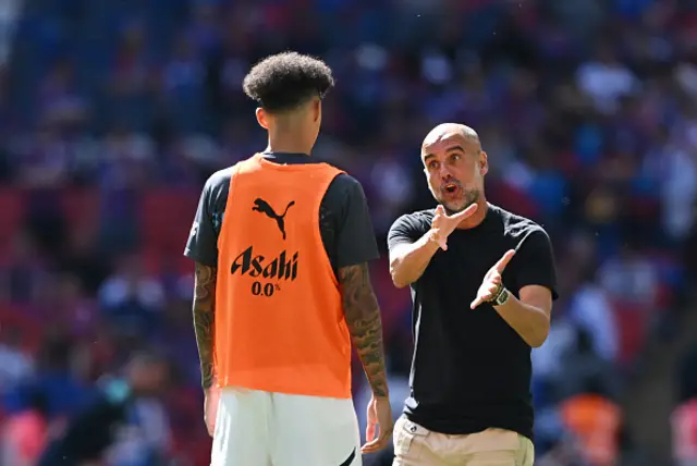 Pep Guardiola, Manager of Manchester City, gives instructions to Nico O'Reilly