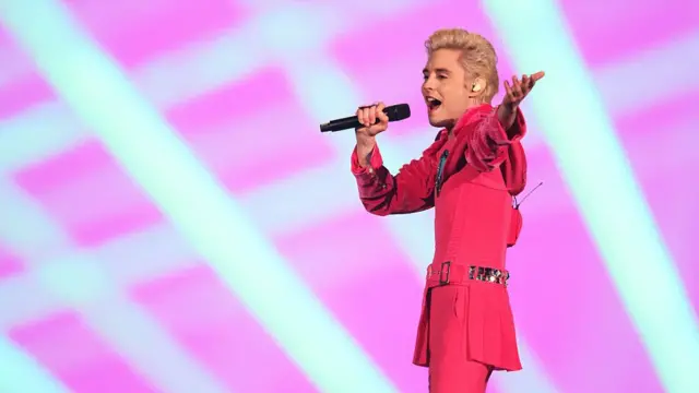 Ukraine singer on stage in pink suit