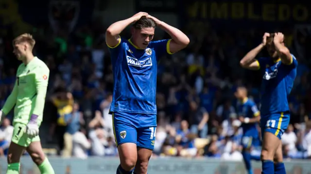 AFC Wimbledon's Matty Stevens holds his head